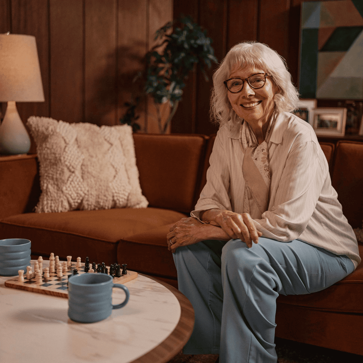 Older adult woman smiling as she plays chess to keep her mind active and engaged